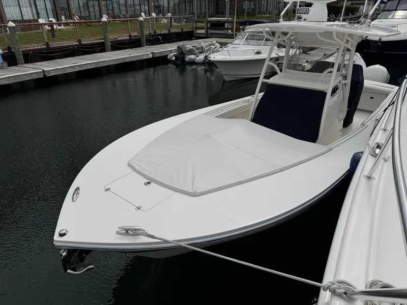 Slide: The Image of 2018 Regulator 28 boat docked in marina, featuring sleek design and spacious deck. - 9
