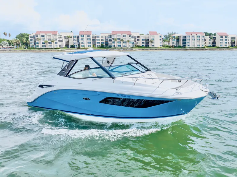 Slide: The Image of 2020 Sea Ray Sundancer 320 cruising on a sunny day near waterfront buildings. - 1