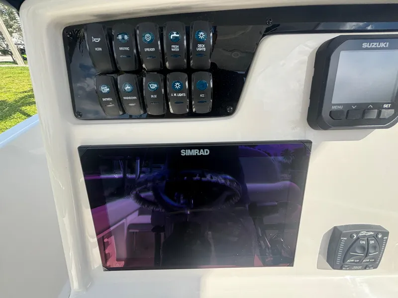 Slide: The Image of 2025 Sailfish 241 CC boat dashboard with Simrad and Suzuki electronics. - 17