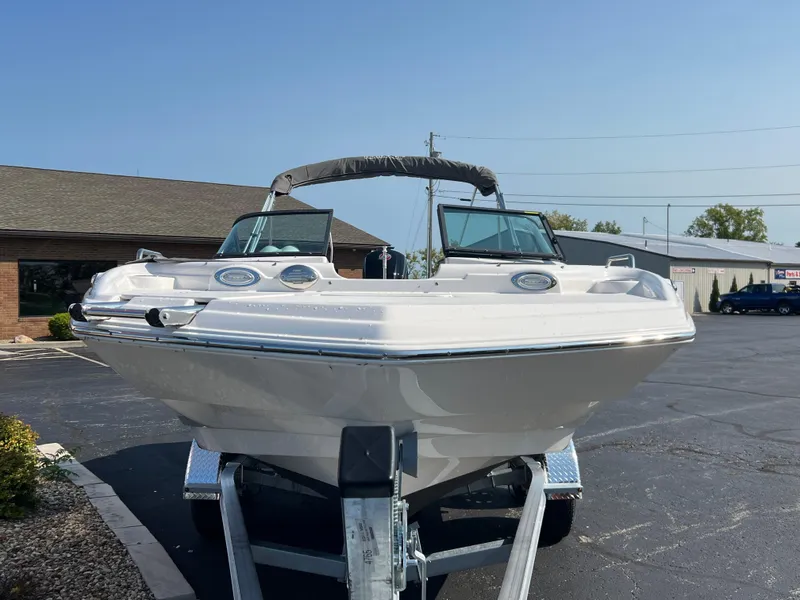 Slide: The Image of 2023 NauticStar 203 DC boat on trailer, parked outdoors under clear sky. - 3