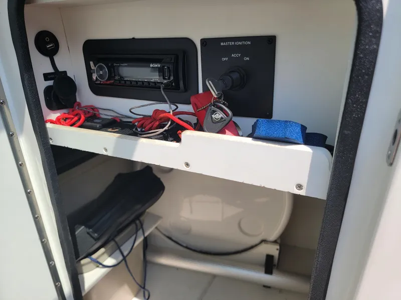Slide: The Image of Storage compartment in a 2011 Sea Ray 240 Sundeck with stereo and ignition keys. - 12