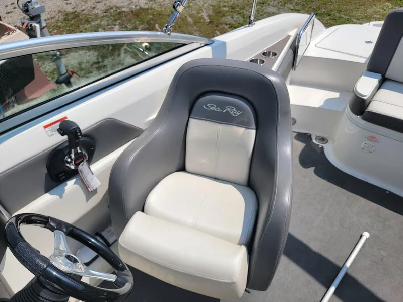 Slide: The Image of 2011 Sea Ray 240 Sundeck boat interior with steering wheel and captain's seat. - 13