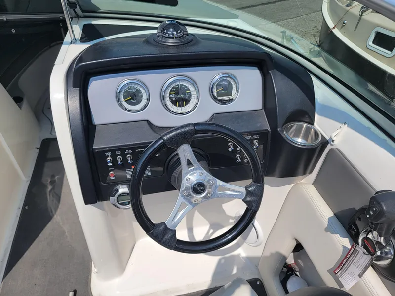 Slide: The Image of 2011 Sea Ray 240 Sundeck dashboard with steering wheel and gauges. - 14