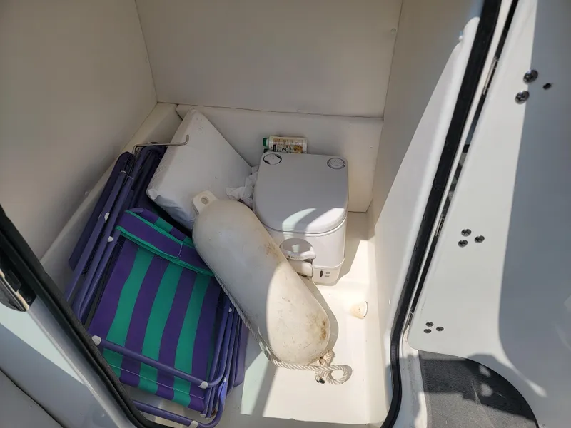 Slide: The Image of Storage compartment in 2011 Sea Ray 240 Sundeck with portable toilet and boating accessories. - 15