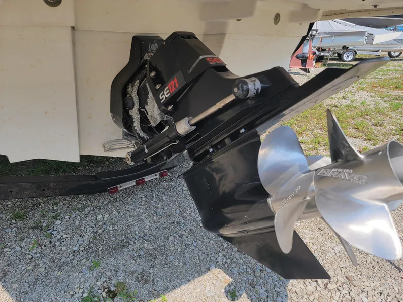 Slide: The Image of 2011 Sea Ray 240 Sundeck boat propeller and outdrive on gravel surface. - 18