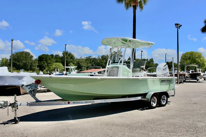 Slide: The Image of 2025 Sea Pro 230 Bay boat on trailer under clear blue sky. - 1