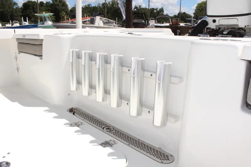 Slide: The Image of 2025 Sea Pro 230 Bay boat interior with rod holders and storage. - 12