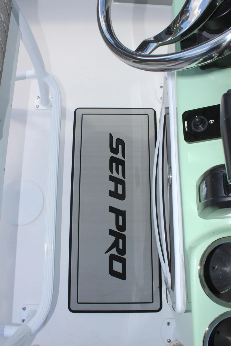Slide: The Image of 2025 Sea Pro 230 Bay boat dashboard with steering wheel and controls. - 26