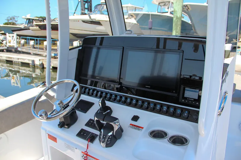 Slide: The Image of 2025 Sea Hunt Gamefish 28 boat dashboard with dual screens and controls. - 32