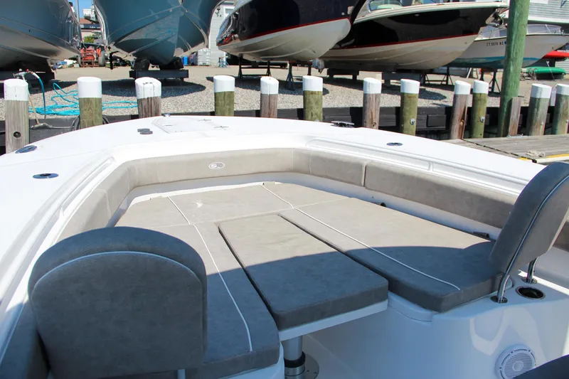 Slide: The Image of 2025 Sea Hunt Gamefish 28 boat interior with cushioned seating and docked boats in background. - 41