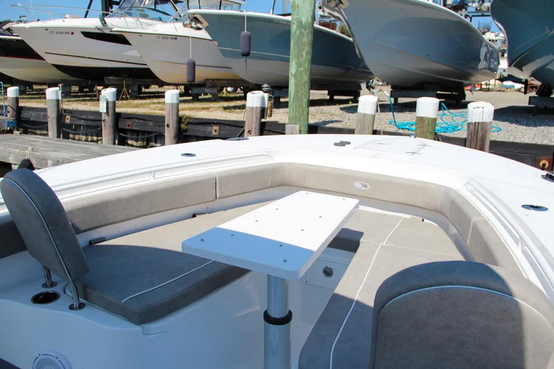 Slide: The Image of 2025 Sea Hunt Gamefish 28 boat interior with seating and table at a marina. - 46