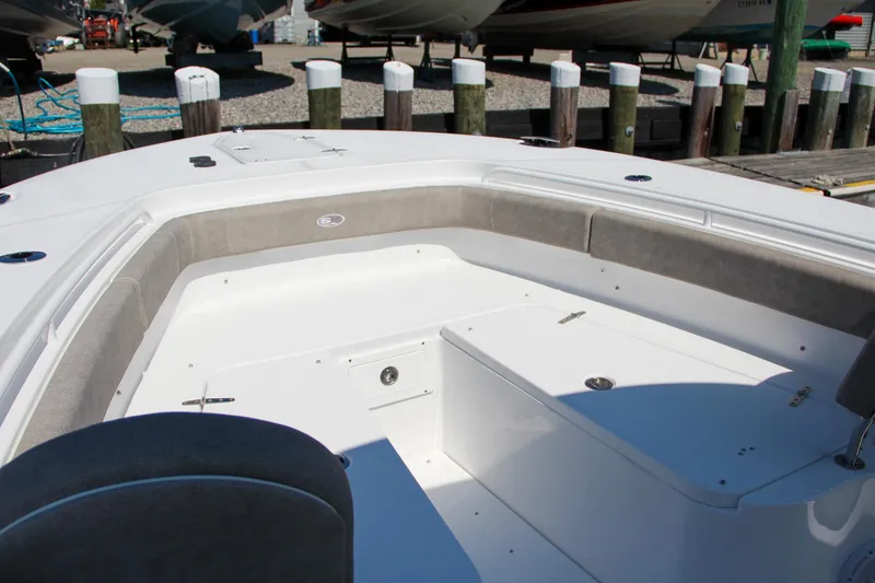Slide: The Image of 2025 Sea Hunt Gamefish 28 boat interior, featuring spacious seating and storage at a marina. - 49