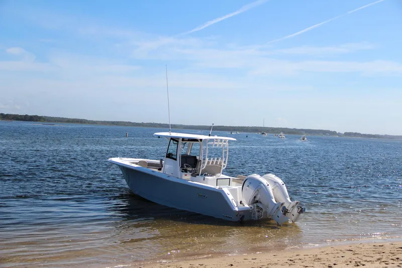 Slide: The Image of 2025 Sea Hunt Gamefish 28 boat anchored on a sandy beach. - 8