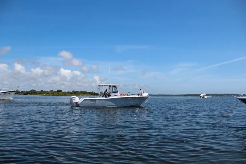 Slide: The Image of 2025 Sea Hunt Gamefish 28 boat on calm water under clear blue sky. - 9