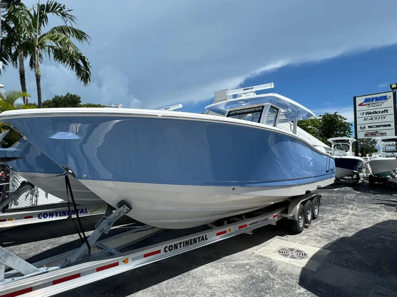 The Image of 2025 Robalo R360 Center Console boat on trailer, displayed outdoors under a clear sky. - 1