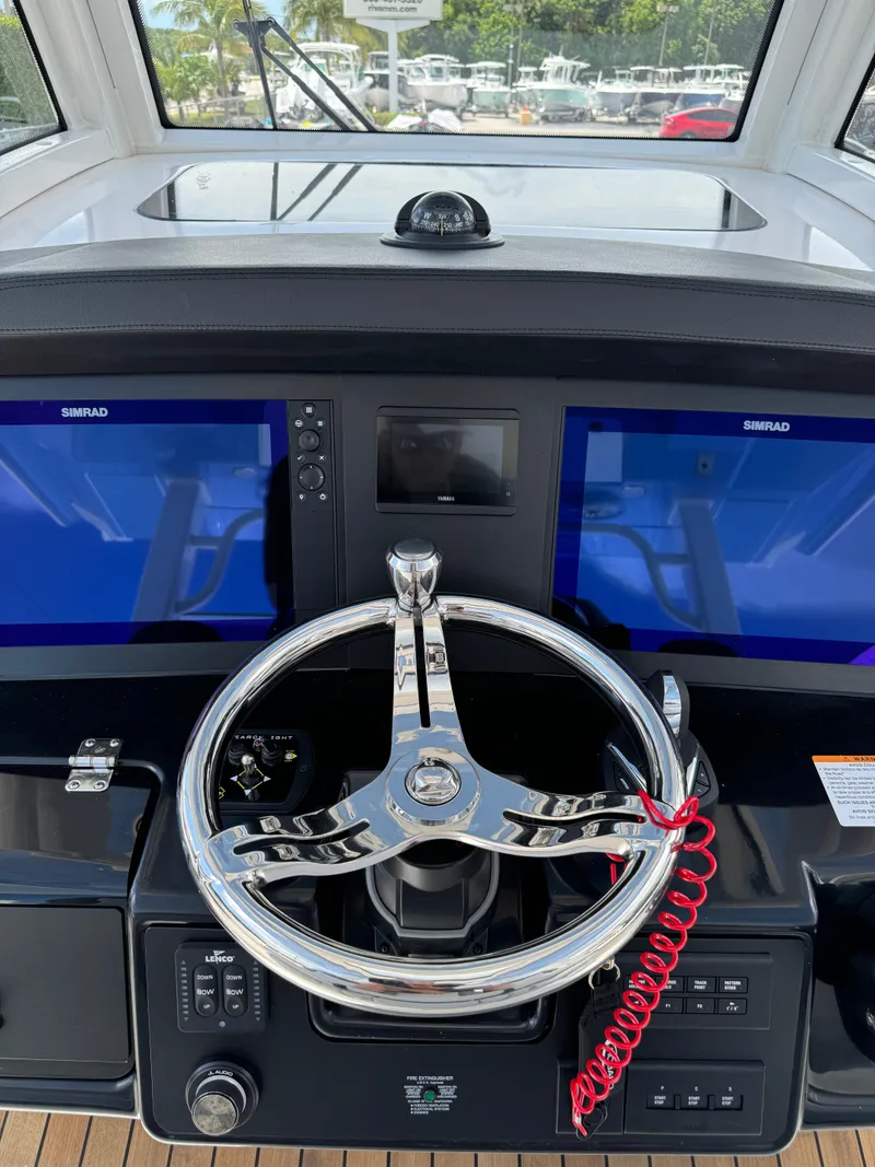Slide: The Image of 2025 Robalo R360 Center Console helm with dual Simrad displays and sleek steering wheel. - 24