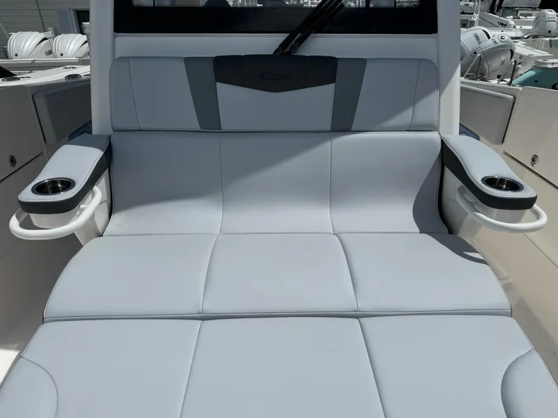 Slide: The Image of 2025 Robalo R360 Center Console boat seating with cup holders, featuring sleek gray upholstery. - 36