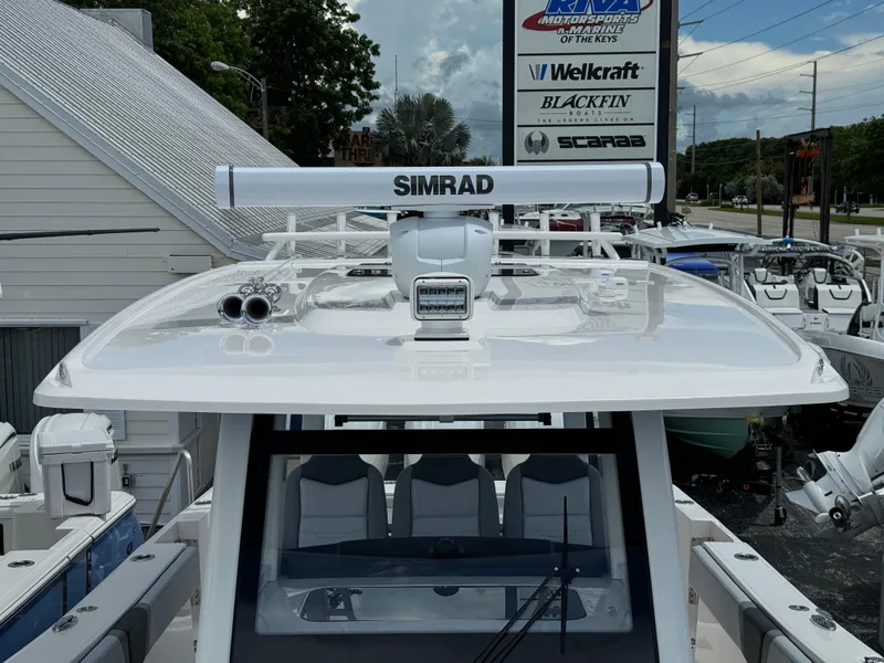 Slide: The Image of 2025 Robalo R360 Center Console boat with Simrad radar, displayed at a dealership. - 46