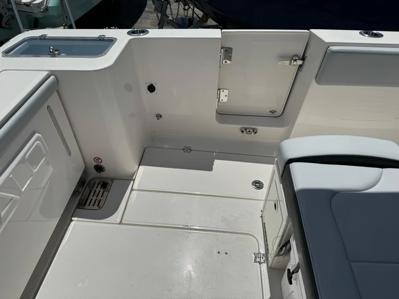 Slide: The Image of 2025 Robalo R360 Center Console boat interior, featuring sleek white seating and storage compartments. - 8