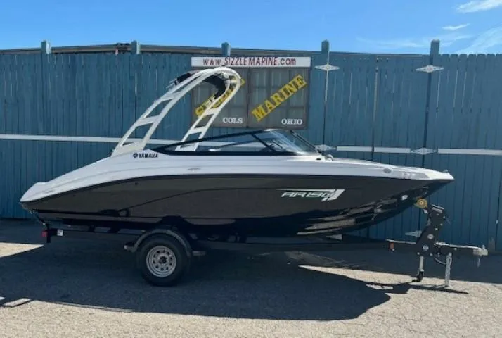 The Image of 2025 Yamaha Boats AR190 on trailer, black and white design, parked outdoors. - 0