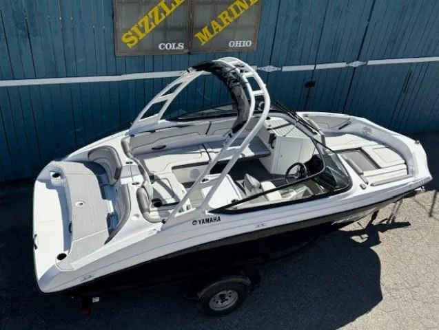 Slide: The Image of 2025 Yamaha Boats AR190 in showroom, sleek design, white and black exterior, Sizzle Marine dealership. - 5