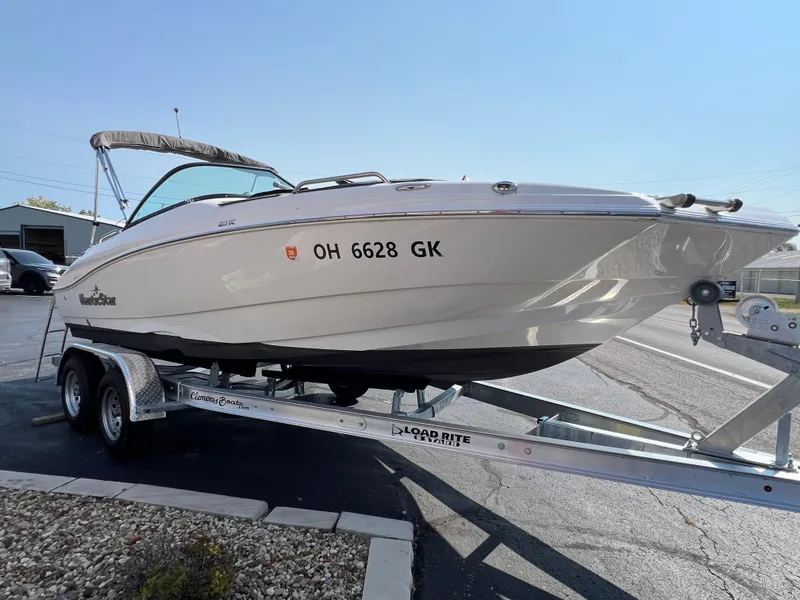 Slide: The Image of 2023 NauticStar 203 DC boat on trailer, parked outdoors under clear sky. - 1