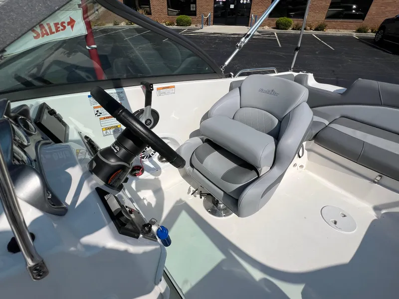 Slide: The Image of 2023 NauticStar 203 DC boat interior with steering wheel and comfortable seating. - 11