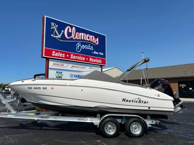 Slide: The Image of 2023 NauticStar 203 DC boat on trailer at Clemons Boats dealership. - 2