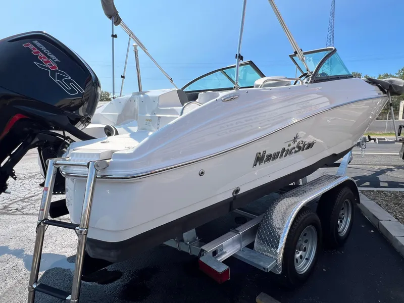 Slide: The Image of 2023 NauticStar 203 DC boat on trailer, featuring sleek design and powerful engine. - 4