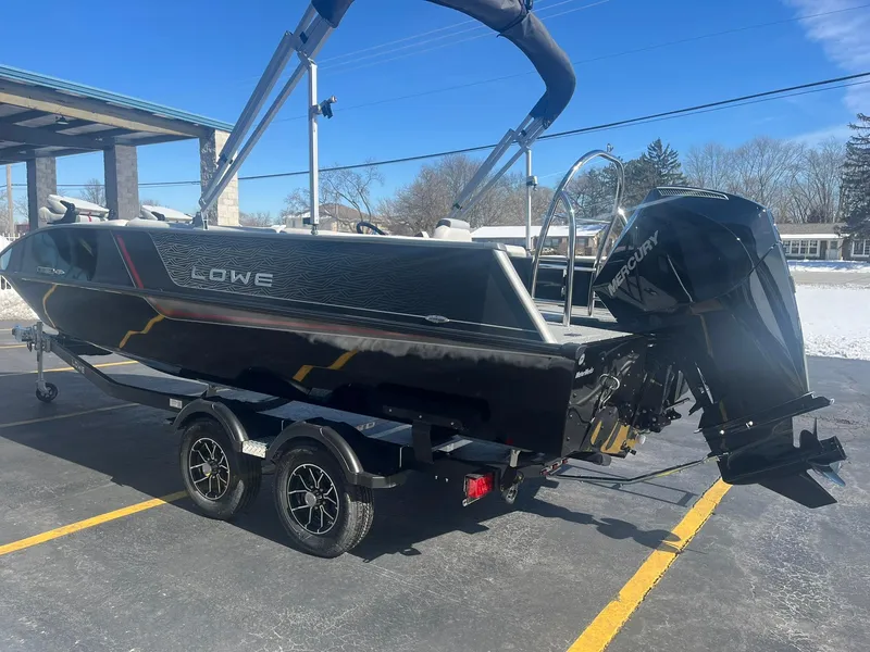Slide: The Image of 2025 Lowe Deck SD224 boat on trailer, featuring a powerful outboard motor. - 2