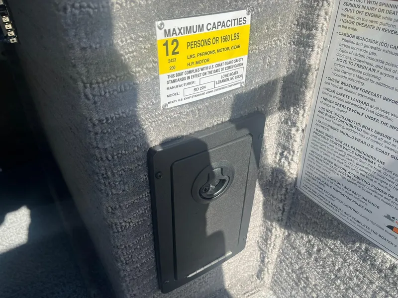 Slide: The Image of Capacity label on 2025 Lowe Deck SD224 boat, showing 12-person limit. - 22