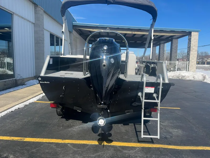 Slide: The Image of 2025 Lowe Deck SD224 boat with outboard motor and ladder, parked outdoors. - 3