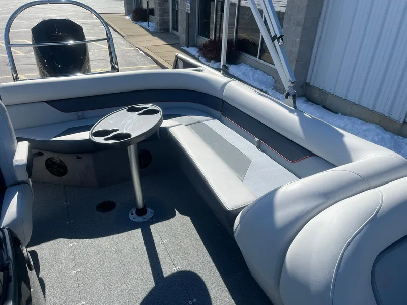 Slide: The Image of 2025 Lowe Deck SD224 boat interior with gray seating and cupholder table. - 6