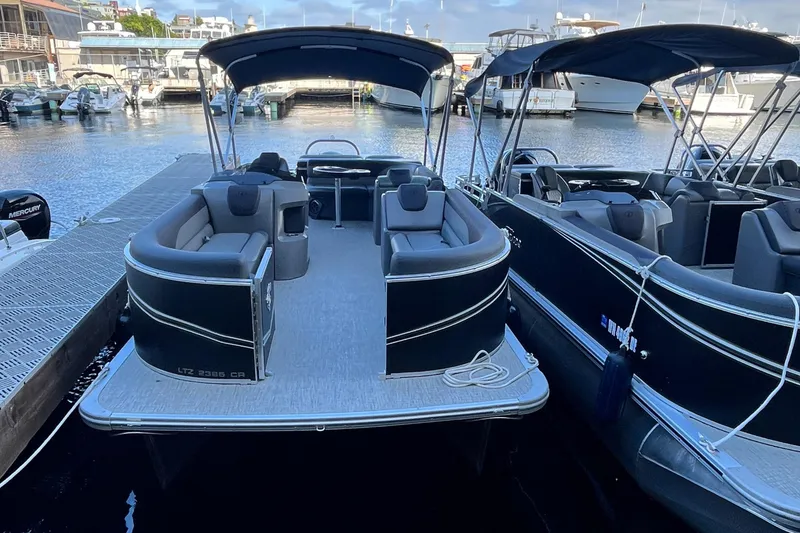 Slide: The Image of 2023 Tahoe Pontoon LTZ Cruise boat docked at marina, featuring sleek design and spacious seating. - 13