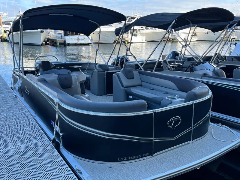 Slide: The Image of 2023 Tahoe Pontoon LTZ Cruise boat docked at marina, featuring spacious seating and canopy. - 4