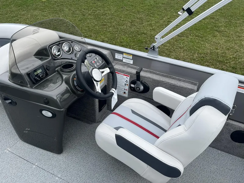 Slide: The Image of 2025 Lowe Deck SD224 boat cockpit with steering wheel, gauges, and comfortable seating. - 16