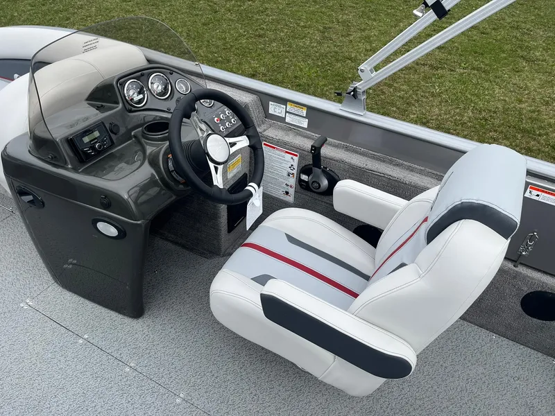 Slide: The Image of 2025 Lowe Deck SD224 boat cockpit with steering wheel and white captain's chair. - 19