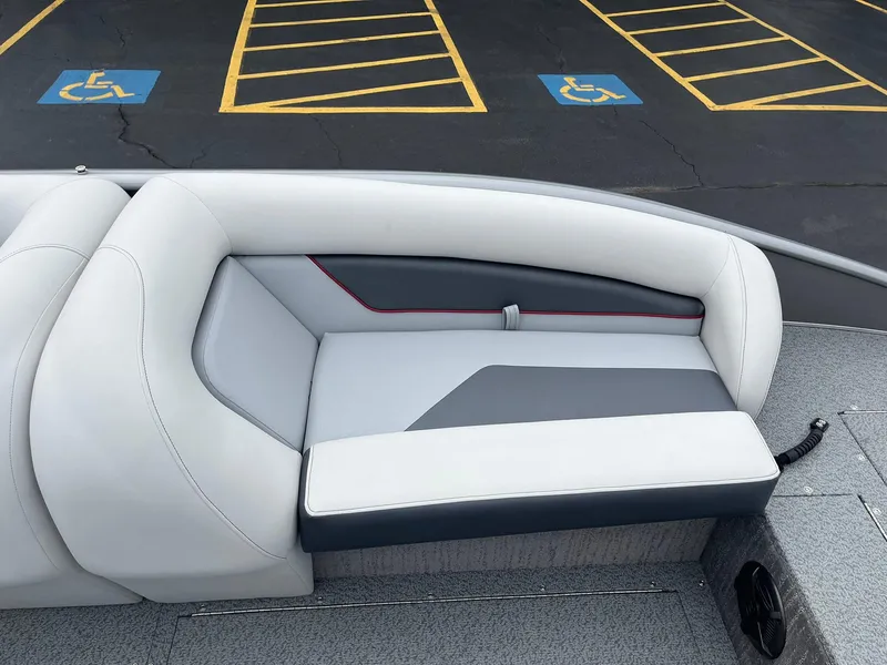 Slide: The Image of 2025 Lowe Deck SD224 boat interior with gray and white seating, parked near accessible spaces. - 27