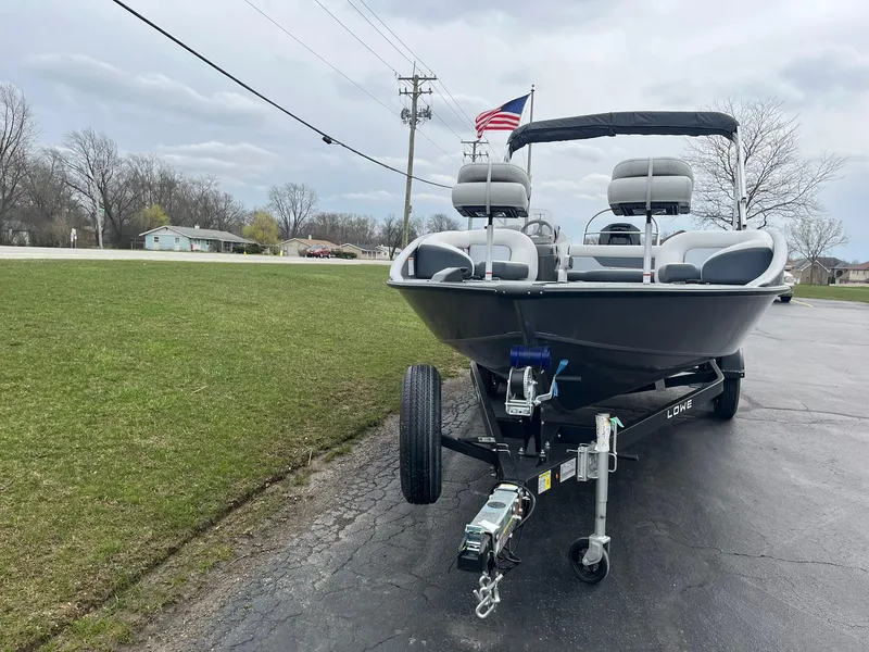 Slide: The Image of 2025 Lowe Deck SD224 boat on trailer, parked on paved road with grassy background. - 3