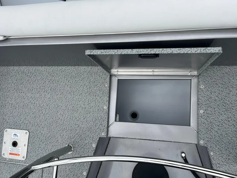 Slide: The Image of 2025 Lowe Deck SD224 boat storage compartment with gray interior and metal railing. - 34