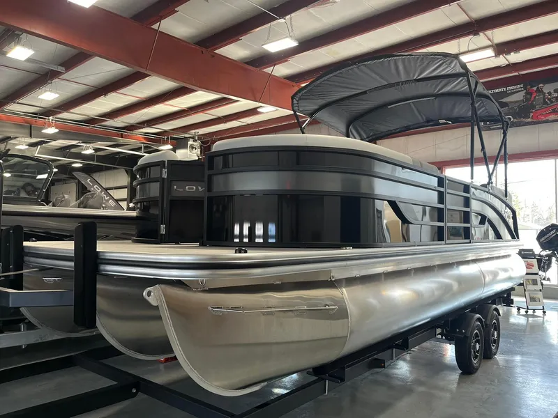 Slide: The Image of 2025 Lowe SS 230 WV pontoon boat in showroom, side view. - 2