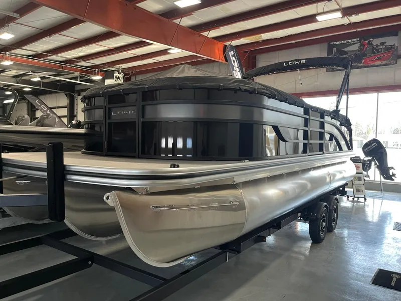Slide: The Image of 2025 Lowe SS 230 WV pontoon boat in showroom, sleek design, metallic finish. - 26