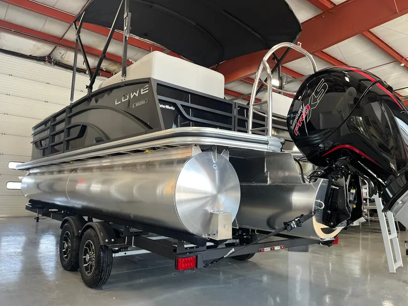 Slide: The Image of 2025 Lowe SS 230 WV pontoon boat with outboard motor in a garage. - 28