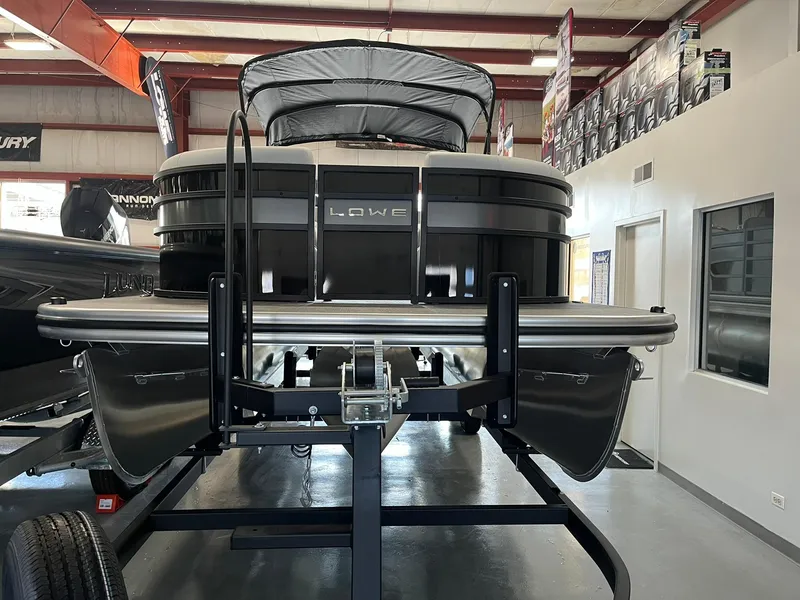 Slide: The Image of 2025 Lowe SS 230 WV pontoon boat displayed indoors on a trailer. - 4