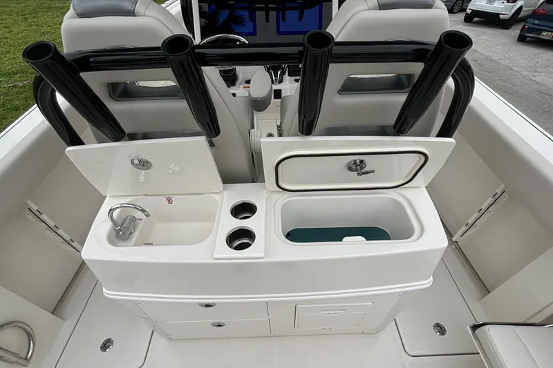 Slide: The Image of 2025 Sailfish 272 CC boat interior with sink, storage, and rod holders. - 13