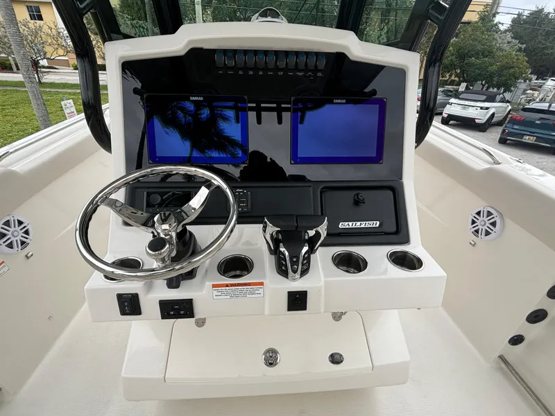 Slide: The Image of 2025 Sailfish 272 CC boat dashboard with steering wheel and dual screens. - 18