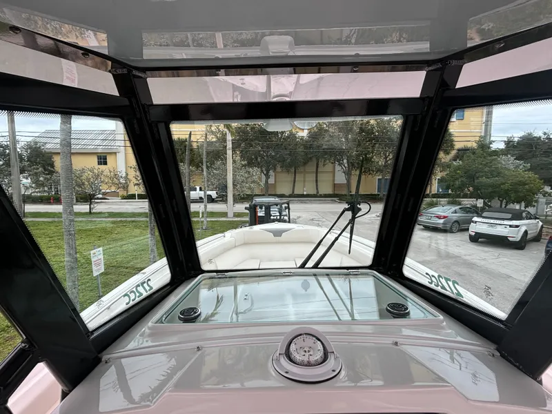 Slide: The Image of 2025 Sailfish 272 CC boat interior view through windshield, parked outdoors. - 19