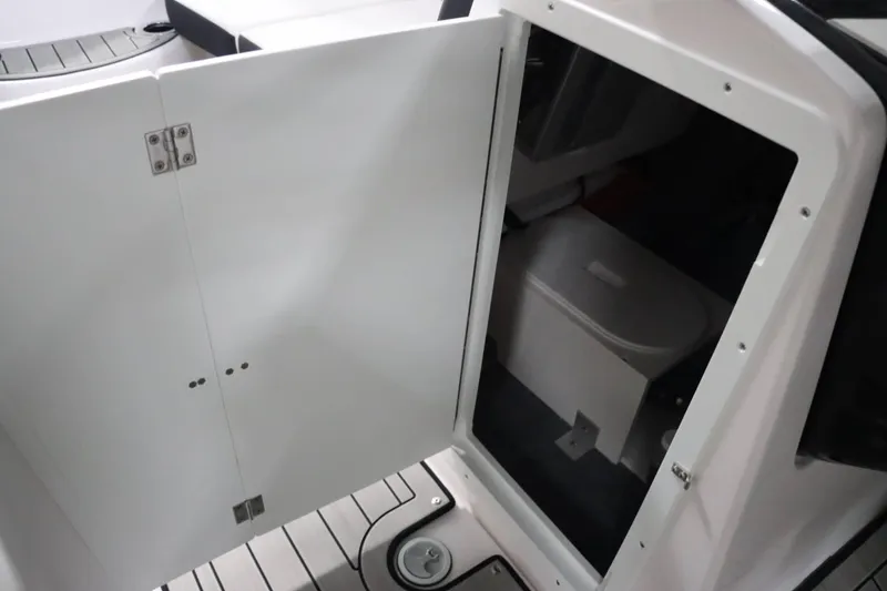 Slide: The Image of 2025 Yamaha Boats 222SD interior storage compartment with open door. - 20