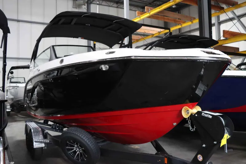 Slide: The Image of 2025 Yamaha Boats 222SD in showroom, black and red hull on trailer. - 5