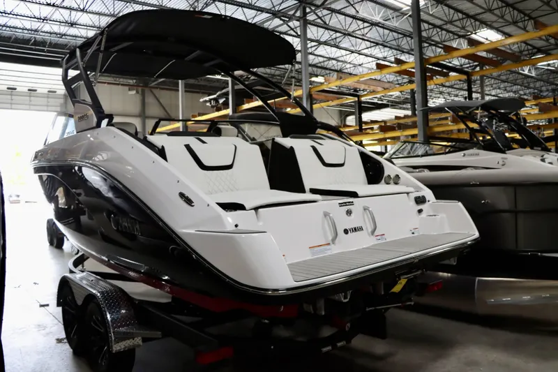 Slide: The Image of 2025 Yamaha Boats 222SD in showroom, sleek design, black and white exterior. - 8
